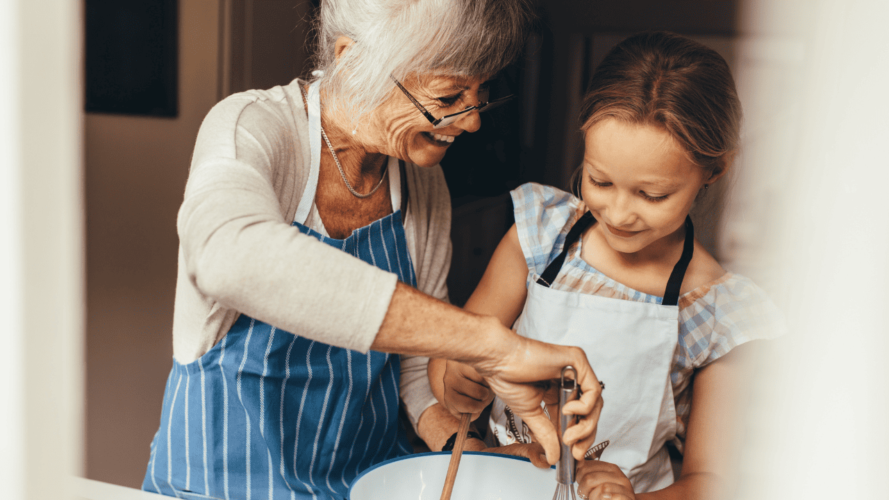 Grandmother cooking in the kitchen with her granddaughter