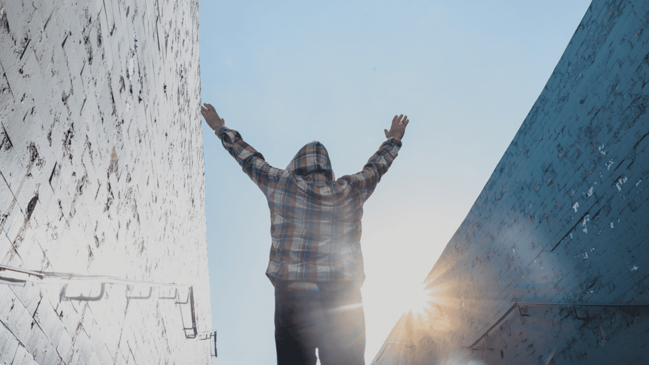 Man walking upstairs raising hands happily